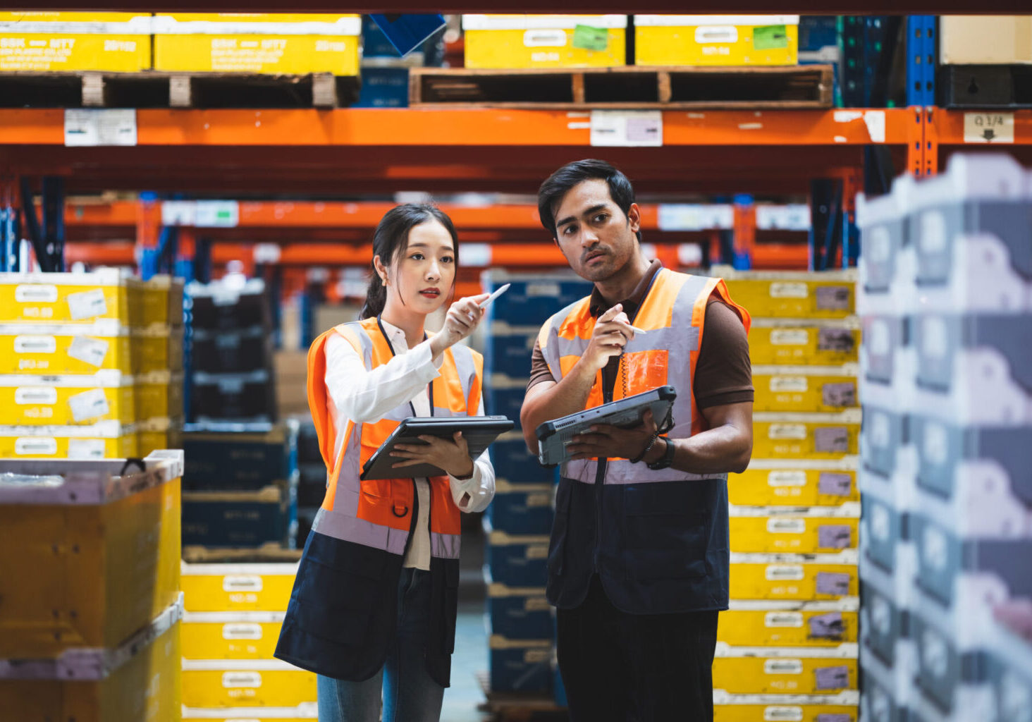 Warehouse worker and manager checks stock and inventory with using digital tablet computer in the retail warehouse full of shelves with goods. Working in logistics, Distribution center.